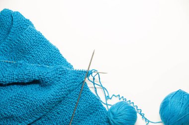 Örgü ürünün bir parçası beyaz arka planda örme sürecinde