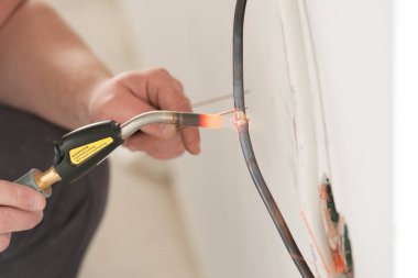 Teknisyen havalandırma sisteminin bakır borusundaki hasarı temizler.