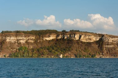 Nehrin manzarası ve arka planda kayalık bir kıyı güzel bulutlu bir gökyüzünün.