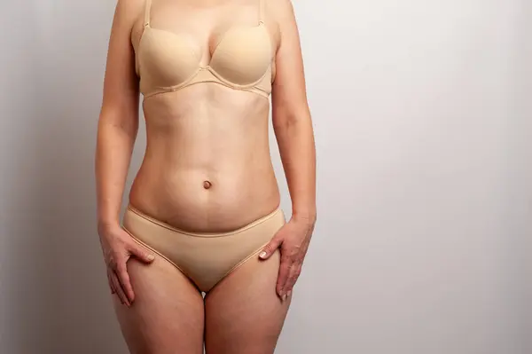 Tıbbi muayene için iç çamaşırlı olgun bir kadının vücudunu gösteriyor.