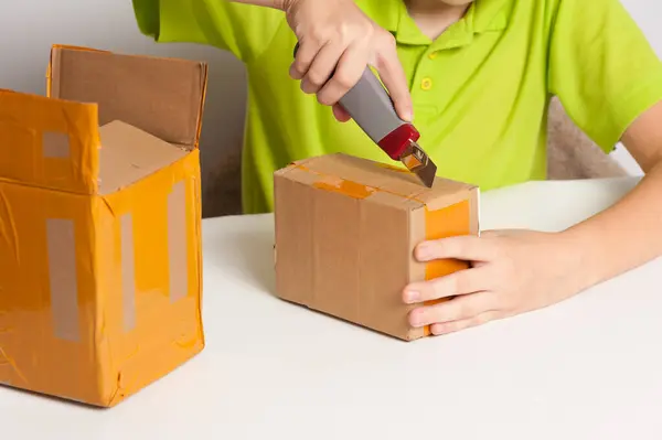 Çocuk bir paketle kutuyu açıyor.