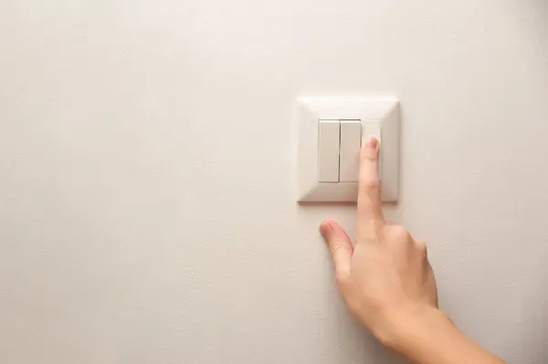 Bir el elektrik düğmesine basıyor.