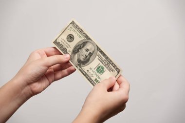 100 dolarlık banknot elinde.