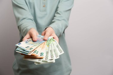 Elinde bir sürü para tutan genç bir adam onu almayı teklif ediyor.