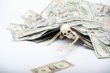 a toy skeleton under the rubble of a huge pile of dollars clipart