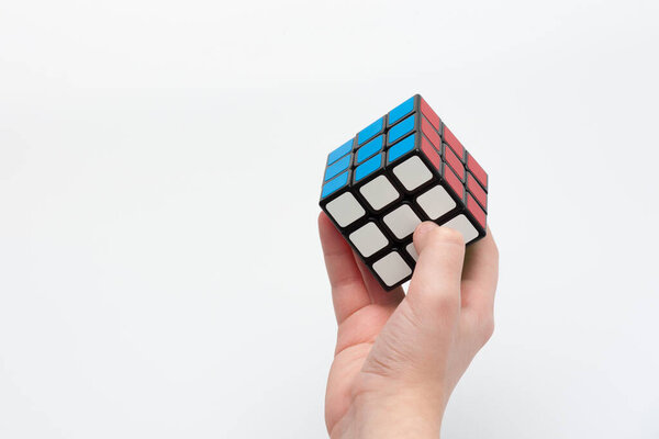 Lviv, Ukraine - 04.25.2022: a human hand passes a puzzle cube with a solved task
