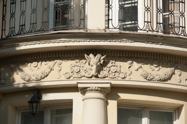 Güzel bir sıva süslemesi ve keçi kabartması olan eski bir binanın ön cephesi.