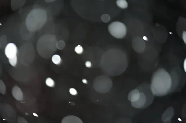 Karanlıktaki kar fırtınası sırasında bulanık kar tanelerinin dokusu