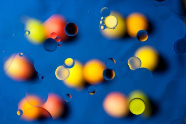 Su yüzeyindeki bulanık ve renkli arkaplanlı yağ kabarcıklarının soyut görüntüsü