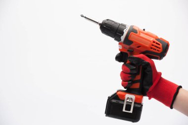 Kırmızı eldivenli bir işçi eli beyaz arka planda elektrikli tornavida tutuyor.