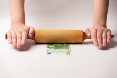 Dünya ekonomisi ve finans konularındaki görüntüler. Mali mutfağın alegorisi. Merdane ve şefin elleri 100 Euro 'luk banknot uzatıyor..