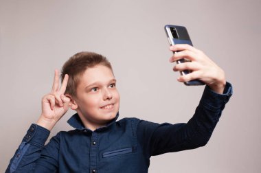 Akıllı telefondan selfie çeken çocuk.