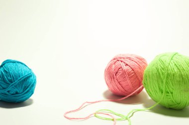 Beyaz arka planda örgü işi için renkli bir ipliğin tüyleri.