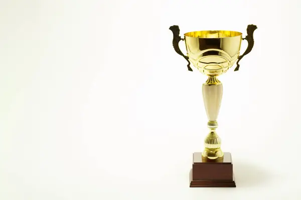 Işık arkaplanındaki altın bardak