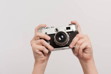 Elinde retro kamera olan bir fotoğrafçının ellerini kaldırdı.