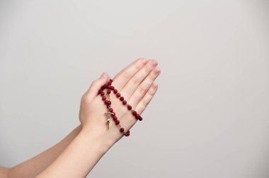 folded hands of a young man holding a rosary during of a pray clipart