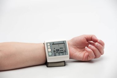 Dijital basınç göstergesi ve insan elinin üzerindeki bazı göstergeler. Genç bir kadının evdeki kan basıncını ölçme süreci