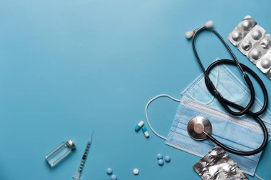 steteskop, koruyucu ekipman ve tıbbi ilaçlar ve cihazlar mavi arkaplanda kopyalama alanı ile