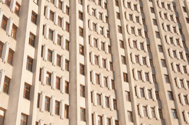 Pencereler simetrik desenli bir gökdelenin minimalist cephesi