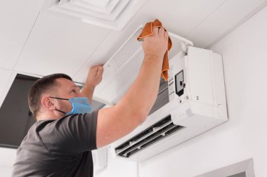 Çalışan, içerideki havalandırma ünitesini temizler ve hizmet eder.