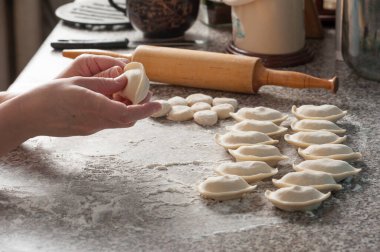 Preparation of traditional Ukrainian dishes. The process of hand molding dumplings at home. clipart