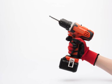 Kırmızı eldivenli bir işçi eli beyaz arka planda elektrikli tornavida tutuyor.