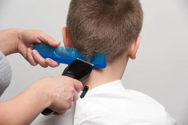 Saç kesme makinesi ve tarak kullanarak kafa ve boyun arkasında saç kesimi.
