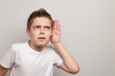 Beyaz tişörtlü beyaz çocuk sessizliğin içinde dinliyordu.