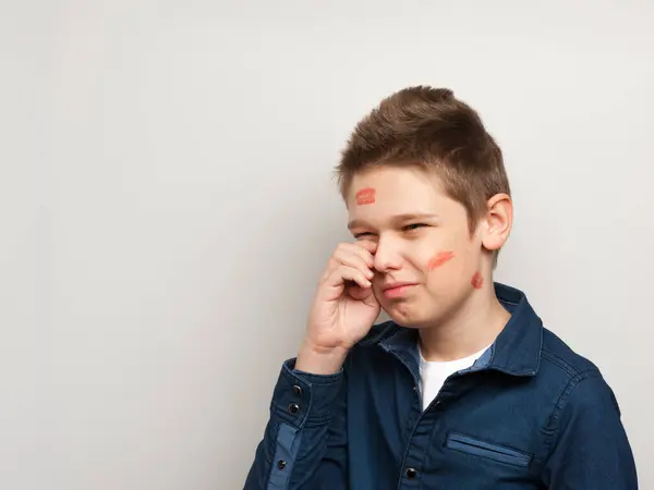 Kadın dudaklarının izleriyle ağlayan çocuk gözyaşlarını siler.