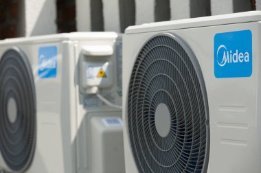 Lviv, Ukraine - 05.16.2022: a pair of new outdoor air conditioner units installed on the wall of the house clipart