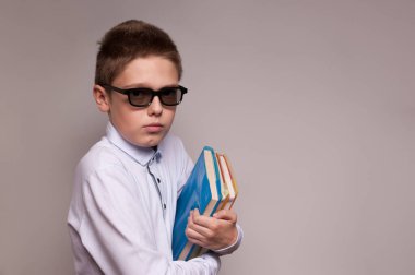 Elinde bir yığın kitap tutan okul çocuğu.