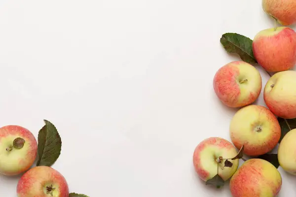 Beyaz arka plandaki hasır plakada sulu olgun elmalar. Yüksek açı görünümü