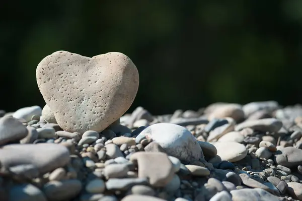 Kalp şeklinde taş, koyu bulanık arkaplanda güzel desenli bir yüzey.