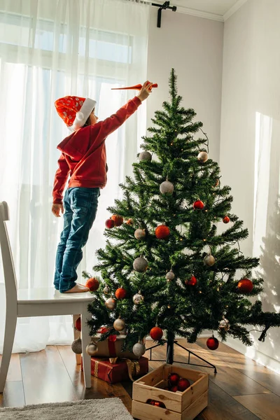 Noel Baba şapkalı bir çocuk evdeki yılbaşı ağacını süslüyor ve ağacın tepesine bir Noel oyuncağı koyuyor. Çocuklar Noel ve yeni yılı kutlamaya hazırlanıyorlar..