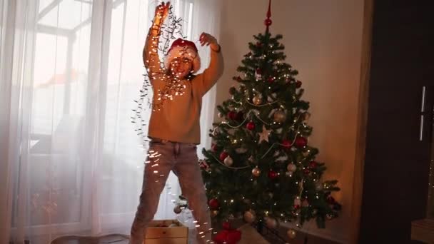 クリスマスツリーの隣の部屋で 新年のガーランドと楽しい十代の女の子が踊ります メリークリスマスと新年 — ストック動画