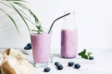 Blueberry smoothie in a glass on the table. Ideal for vegetarian breakfast, diets and detox. 