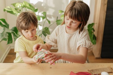 Bir erkek ve bir kız kardeş, Paskalya yumurtalarını tavşan şeklinde kumaştan yapıyorlar. Paskalya için aile hazırlıkları.