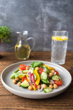 Nohut, domates, kırmızı soğan, salatalık ve marullu vejetaryen sebze salatası. Protein ve lif açısından zengin vejetaryen yemekleri.