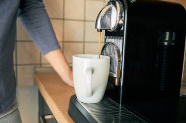 Espresso makinesinde espresso yapan genç bir kadının elleri.. 