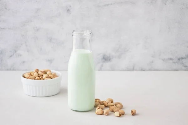 Pistaschmjölk Flaska Ett Grått Bord Bredvid Pistaschmandlar Växtmjölk — Stockfoto