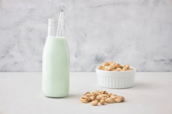 Pistaschmjölk Flaska Ett Grått Bord Bredvid Pistaschmandlar Vegetabilisk Mjölk Nötmjölk — Stockfoto