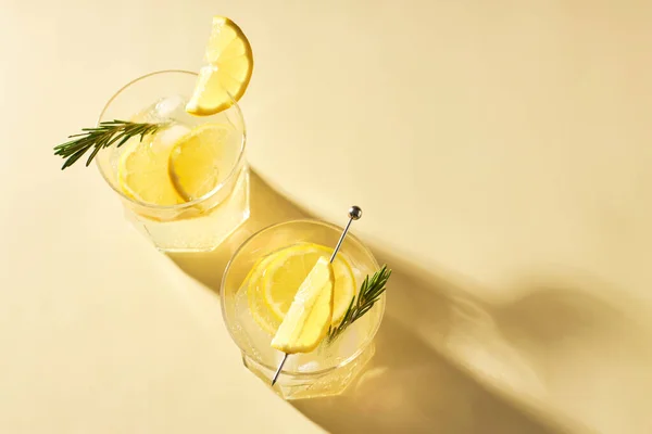 Освежающие Летние Напитки Свежим Лимоном Украшенным Веточкой Розмарина Сером Столе — стоковое фото