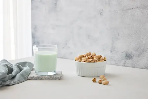 Ein Glas Pflanzenmilch Aus Nüssen Auf Dem Tisch Neben Pistazien — Stockfoto