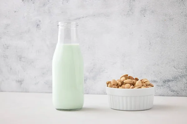 从开心果中自制蔬菜牛奶 在灰色混凝土桌子上的瓶子里放着梨子牛奶 素食者的理想选择 案文的位置 — 图库照片