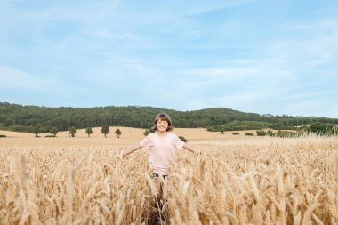 Okul çağında mutlu bir kız, olgun dikenlerle dolu bir tarlada yürüyor. Köy hayatı. Yaz tatili. Tatil kavramı