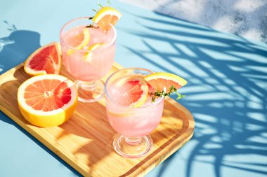 Soğuk yaz içkilerinin en üst görüntüsü greyfurtlu ya da parlak güneşli bir günde ahşap tepside kırmızı portakallı. Turunçgil suyuyla serin bir kokteyl.