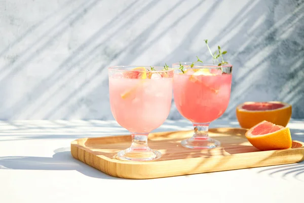 Summer chilled cocktails with citrus fruits. Drink with grapefruit or red orange and a sprig of thyme