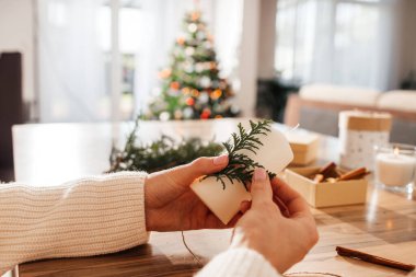 Genç bir kadının Noel ya da yeni yıl için mumları süslemesi. Tatil için süsleme ve hediye yapma.