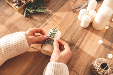 Yeni yıl ya da Noel dekoru ile dekore edilen kızların el resimleri. Kadınlar tatil süslemeleri yapar, ev için mumlar.