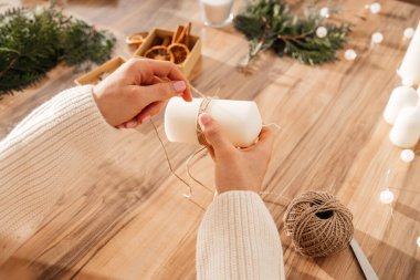 Genç bir kadının Noel ya da yeni yıl için mumları süslemesi. Tatil için süsleme ve hediye yapma.